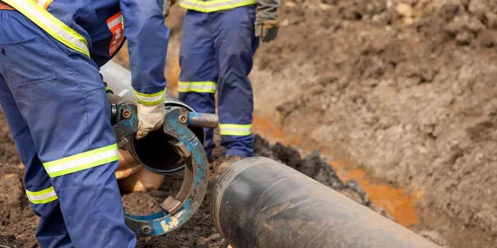 Sewer main pipe replacement crew working on large-diameter line in Miami