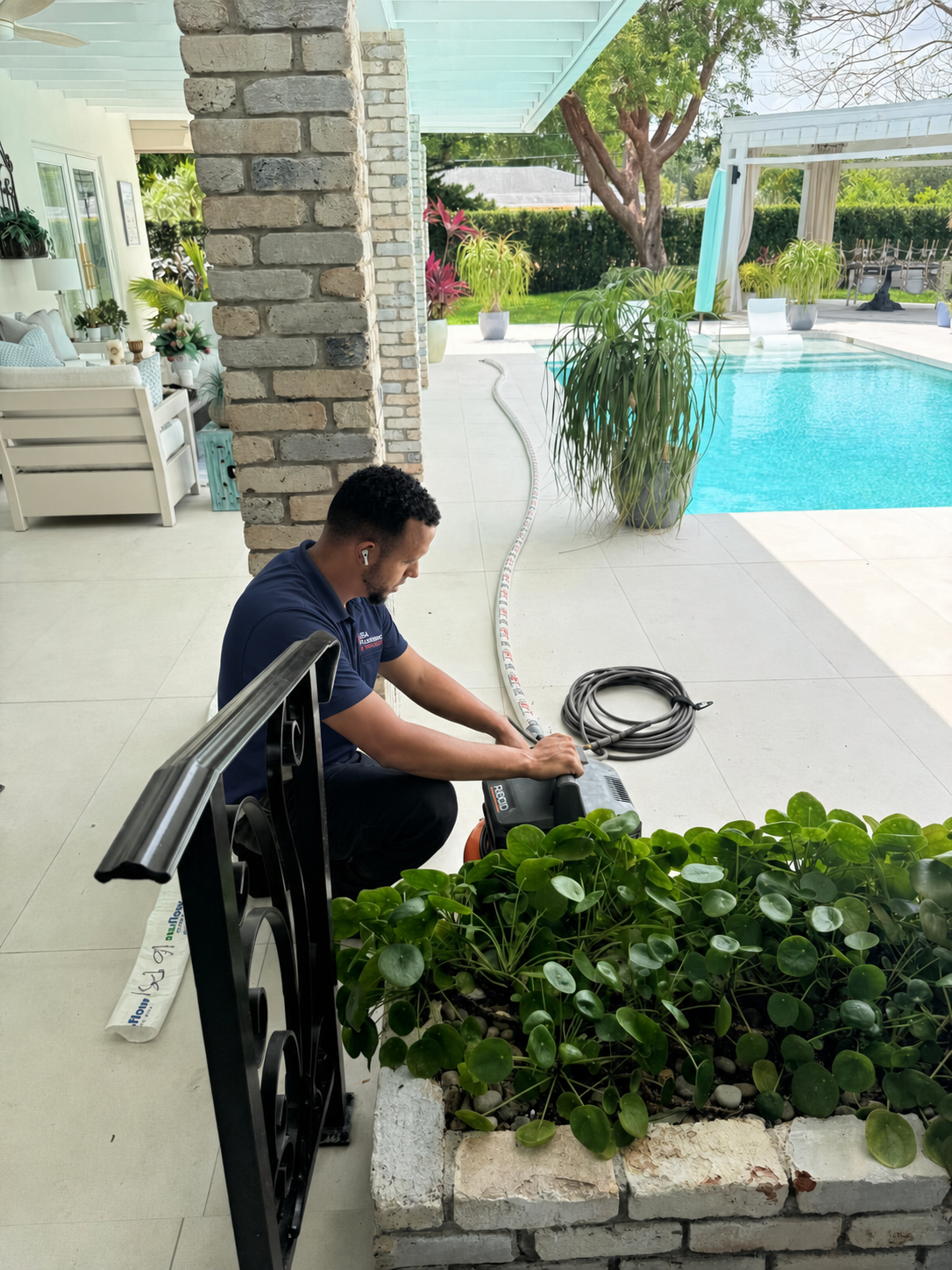 Pipe relining crew staging the inversion drum and curing equipment beside the service van at a Broward home